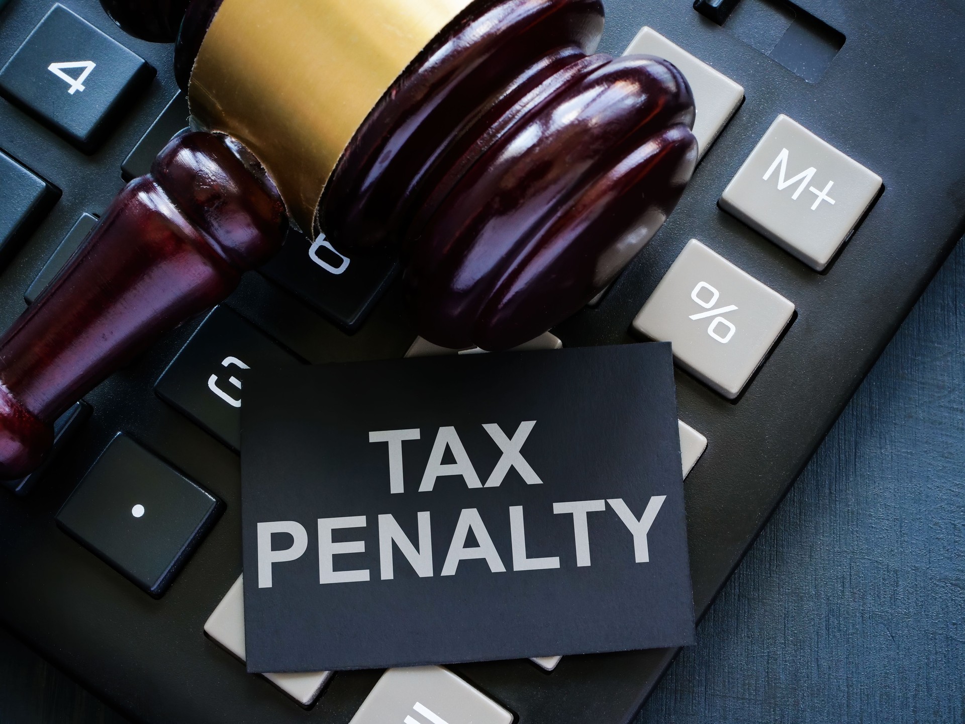 Calculator, a gavel and Tax penalty sign.