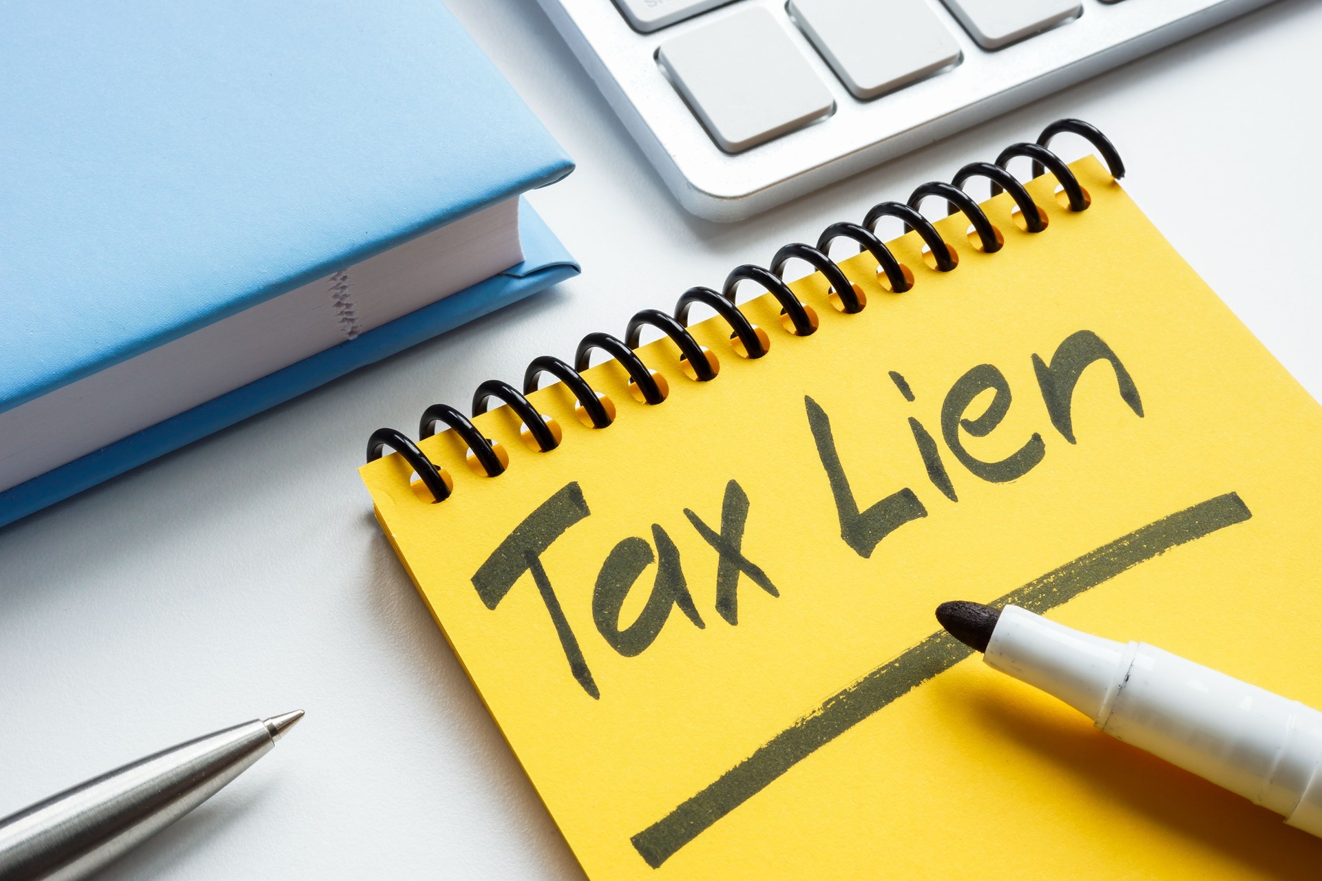 Yellow notepad with tax lien handwritten words.